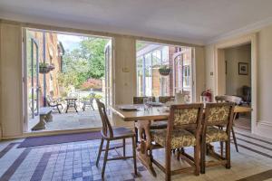 comedor con mesa y sillas y ventana grande en Milton House Group Retreats, en Bedford