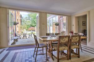 een eetkamer met een tafel en stoelen en een groot raam bij Milton House Group Retreats in Bedford