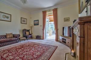 a living room with a couch and a tv at Milton House Group Retreats in Bedford