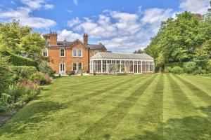 a large lawn in front of a large house at Milton House Group Retreats in Bedford