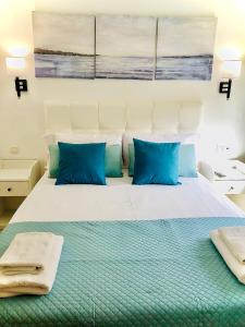 a bedroom with a large bed with blue pillows at Nuestro Rincón en la Playa, Golf y Piscina driver in Torre de Benagalbón