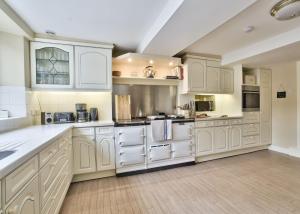 a large white kitchen with white cabinets and appliances at Fawley Court by Group Retreats in Hereford