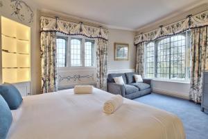 a bedroom with a large white bed and a couch at Fawley Court by Group Retreats in Hereford