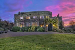 an old stone house with a sunset in the background at Fawley Court by Group Retreats in Hereford