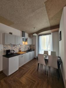 a kitchen with white cabinets and a table and chairs at Apartamenty Katarina in Ustrzyki Dolne