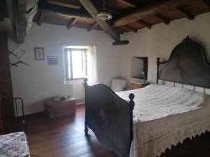 - une chambre avec un grand lit et une fenêtre dans l'établissement La casa del pozzo, à Sillico