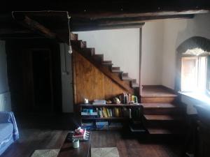 a room with a staircase and a book shelf with books at La casa del pozzo in Sillico