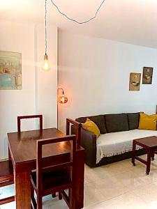 uma sala de estar com um sofá e uma mesa em Nuestro Rincón en la Playa, Golf y Piscina driver em Torre de Benagalbón