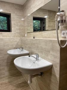 La salle de bains est pourvue de 2 lavabos et d'un miroir. dans l'établissement Chata Lucka, à Bítov