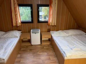 una piccola camera con due letti e due finestre di Chata Lucka a Bítov