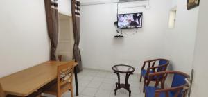 a room with a table and chairs and a tv on the wall at Veronique Christine in Libreville