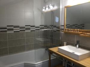 a bathroom with a sink and a shower and a mirror at chambres d'hôtes à la claire fontaine in Sorges