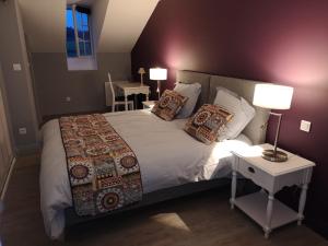 1 dormitorio con 1 cama grande, mesa y lámparas en chambres d'hôtes à la claire fontaine en Sorges