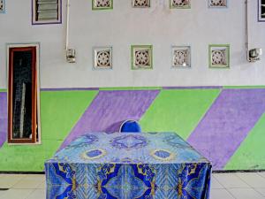stolik w pokoju z malowaną ścianą w obiekcie OYO 91572 Kost Esklusif Barokah w mieście Pasuruan