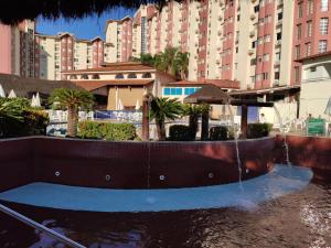 a pool of water in front of a large building at Suíte Hot Springs B3 Hotéis Hospedagem - Até 4 adultos in Caldas Novas