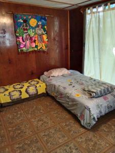 a bedroom with a bed and a painting on the wall at Kyea Inn in Hanga Roa