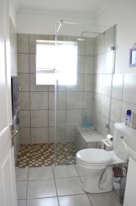 a white bathroom with a toilet and a shower at 24 on Karee in Stilbaai
