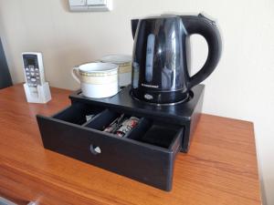 a black cabinet with a tea kettle on top of a table at Biłgoraj Aparthotel in Biłgoraj