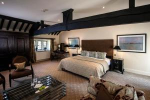 1 dormitorio con 1 cama y sala de estar en The Slaughters Manor House, en Lower Slaughter