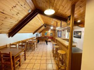 a restaurant with wooden ceilings and tables and chairs at Résidence - Gite La Mourée in Vars
