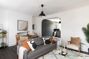 a living room with a gray couch and a table at The Camberwell Retreat - Alluring 2BDR Flat with Garden in London