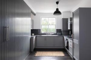 a kitchen with a sink and a window at The Camberwell Retreat - Alluring 2BDR Flat with Garden in London