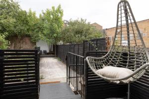 a hammock sitting on a fence in a backyard at The Camberwell Retreat - Alluring 2BDR Flat with Garden in London