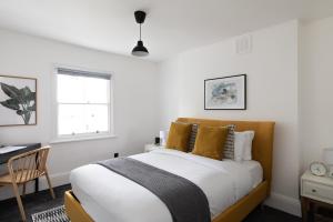 a bedroom with a bed and a desk and a window at The Camberwell Retreat - Alluring 2BDR Flat with Garden in London