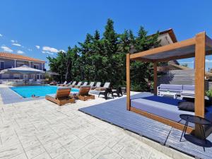 a patio with lounge chairs and a swimming pool at Philoxenia Suites in Nea Vrasna