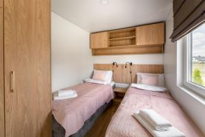 two beds in a small room with a window at Wichrowe Wzgórze Lark House in Kudowa-Zdrój