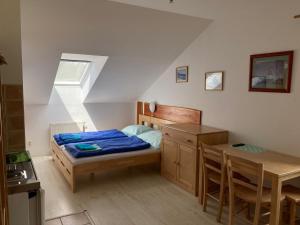 a bedroom with a bed and a desk and a table at SKI-BIKE APARTMENTS in Železná Ruda