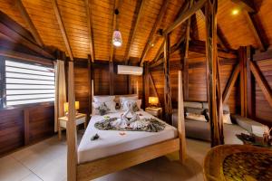 1 dormitorio con 1 cama en una habitación de madera en Karucoco lodge, en Deshaies