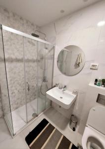 un bagno bianco con doccia e lavandino di New York - Central Point a Podgorica Altre 9 foto