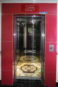 an elevator in a building with a tile floor at Zaineast Hotel in Dubai