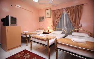 杜拜的住宿－宰勒斯特酒店，一间设有三张床和一台电视的房间