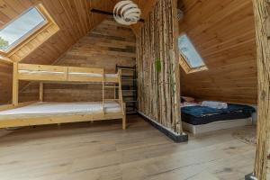 a room with two bunk beds in a wooden cabin at Domek na Wodzie FM - Czarna perła in Mrągowo