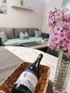 uma garrafa de vinho e um vaso de flores sobre uma mesa em Fewo Krysik Unterdeck em Lühmannsdorf