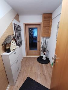 a room with a hallway with a door and a vase of flowers at Fewo Krysik Unterdeck in Lühmannsdorf