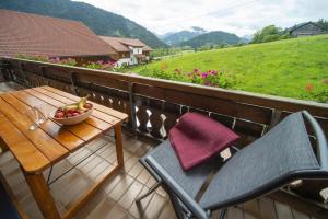 uma mesa e cadeiras numa varanda com uma taça de fruta em Ferienhof Steinmüller em Bad Hindelang