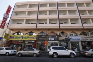 a building with cars parked in front of it at Zaineast Hotel in Dubai