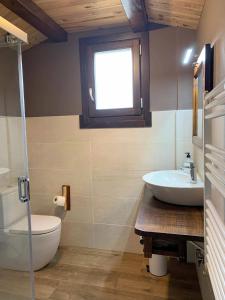łazienka z umywalką, toaletą i oknem w obiekcie Casa rural ELURKOIA w mieście Isaba
