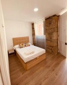 a bedroom with a bed and a stone wall at Albergue y Gelateria il nonno in Sarria