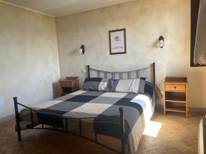 ein Schlafzimmer mit einem Bett mit einer blauen und weißen Decke in der Unterkunft Il Borgo Affitacamere in Castiglione in Teverina