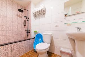 La salle de bains est pourvue de toilettes avec un siège bleu. dans l'établissement LoveBaby Homestay, à Luodong