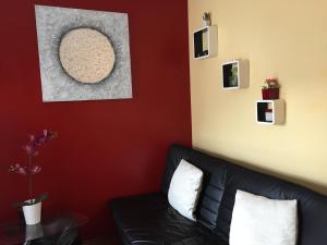 een woonkamer met een zwarte bank en een rode muur bij Studio-Apartment Sven in Bonn