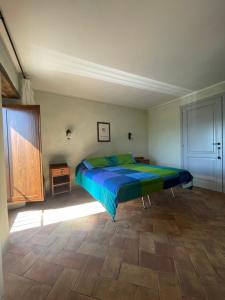 Schlafzimmer mit einem Bett mit einer blauen und grünen Bettdecke in der Unterkunft Il Borgo Affitacamere in Castiglione in Teverina