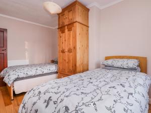 a bedroom with two beds and a wooden cabinet at The Perch in Bexley