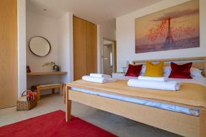 a bedroom with a large bed with red and yellow pillows at Nye Creek Or Nye Creek & Little Nye in Milford on Sea