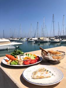 two plates of food on a table near a marina at Karpaz Gate Marina Hotel in Ayia Trias