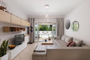 un soggiorno con un divano e una TV di Villa Maria Rose a Kassiopi